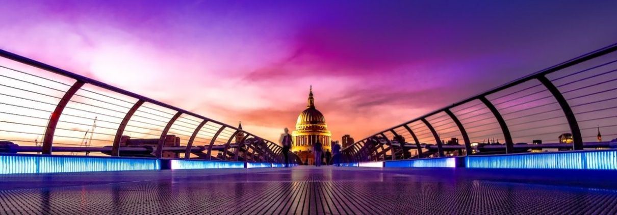 The dome of St Paul's Cathedral is illuminated in front of a purple sky