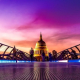 The dome of St Paul's Cathedral is illuminated in front of a purple sky