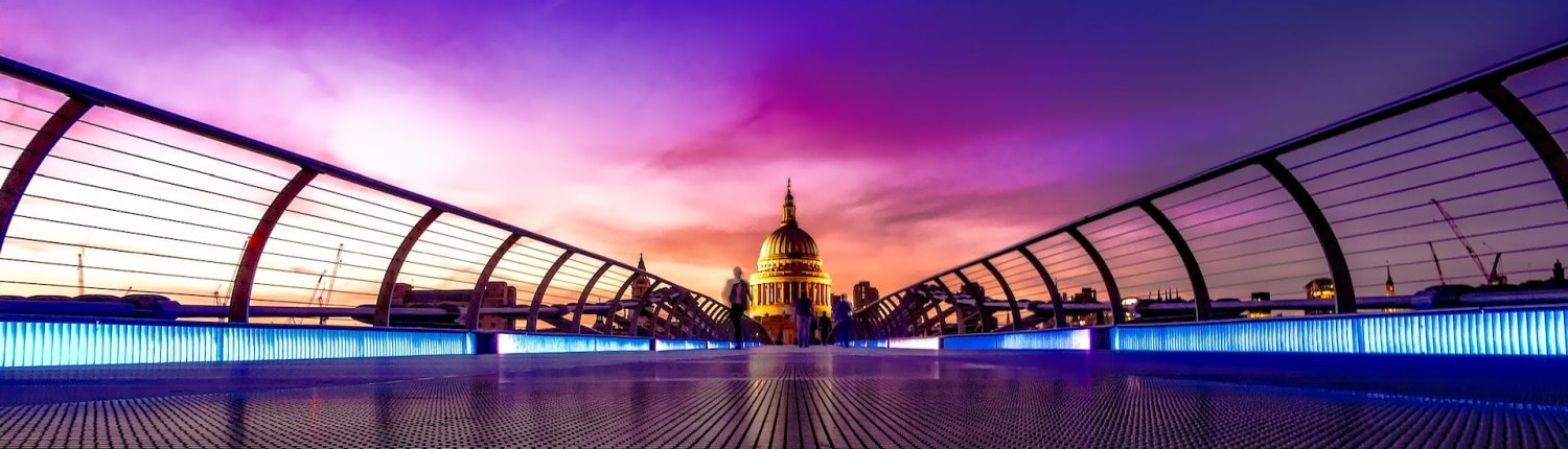 The dome of St Paul's Cathedral is illuminated in front of a purple sky