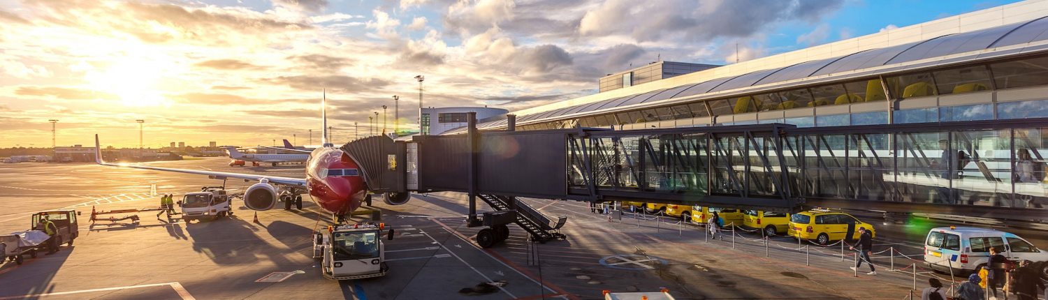 A passenger jet waiting at the departure gate of a large airport