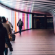 Commuters walk purposefully down a curved tunnel at a train station